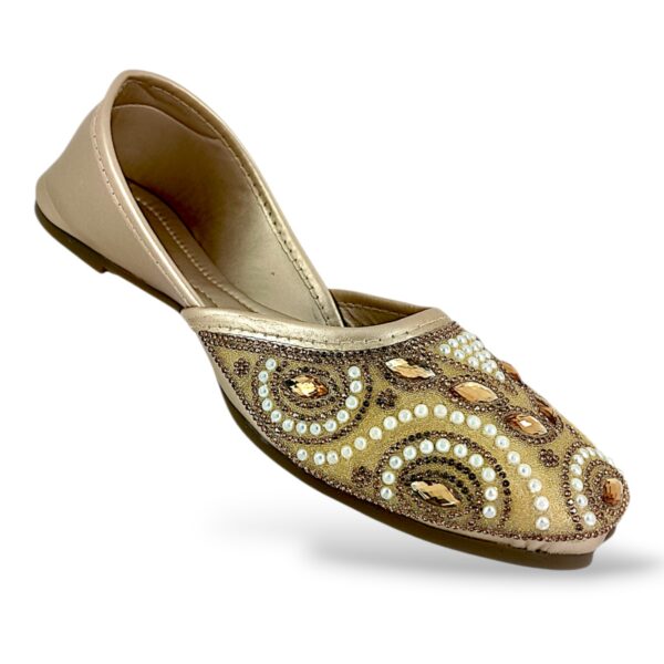 Elegant traditional ethnic footwear from our women's juttis wholesale collection featuring intricate pearl embroidery and crystal embellishments on a flat sole.